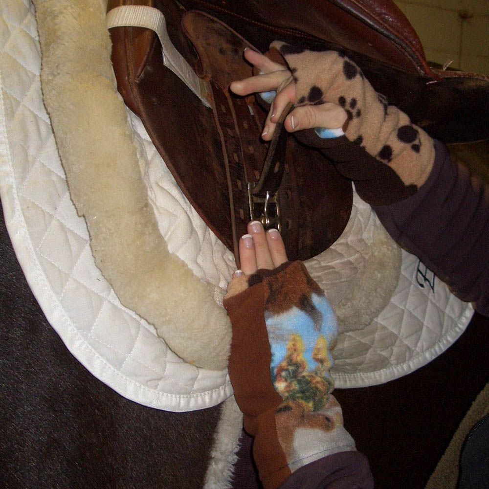 Person holding horse reins and making a peace sign gesture.